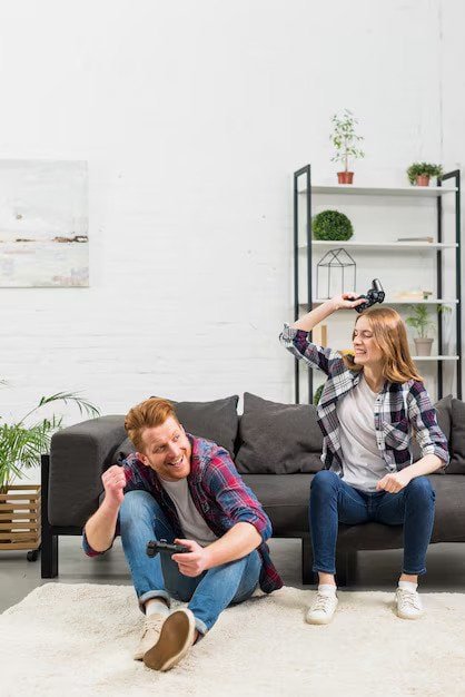 young-woman-sitting-sofa-hitting-her-boyfriend-with-joystick_23-2148049501 (1)